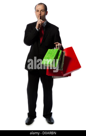 Geschäftsmann mit Einkaufstüten und ruhigen Zeichen mit der Hand, vertikale erschossen isoliert auf weiss. Stockfoto