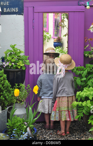 KLEINES MÄDCHEN BLICK AUF SICH SELBST IN EINEM SPIEGEL IM GARTEN VON IHREM HAUS CAYEUX-SUR-MER BUCHT DER SOMME SOMME (80) FRANKREICH Stockfoto