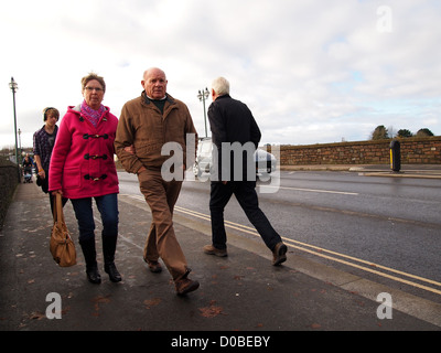 Älteres Paar, die über die alte Brücke in Barnstable, Devon, England, UK, November 2012 Stockfoto