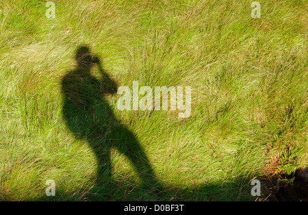 A Schatten selbst Porträt des Fotografen während Sie Fuß. Stockfoto