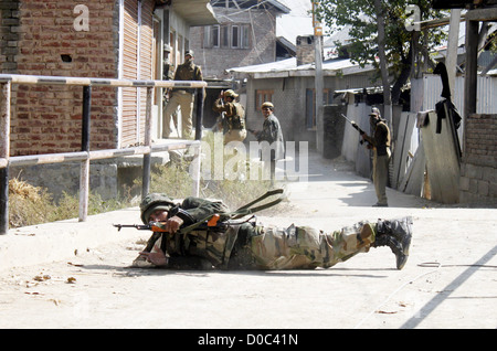 Ein Soldat der indischen Armee liegt, wie er seine Position während einer Schießerei am Stadtrand von Srinagar Indien - 21.10.10 nimmt Stockfoto