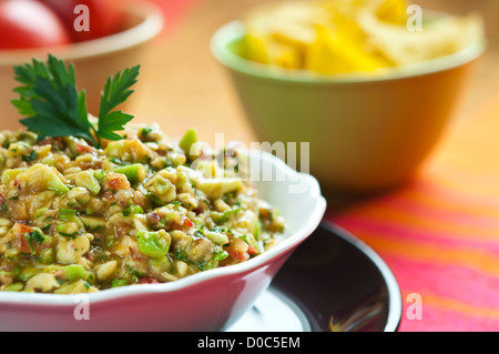 Guacamole-Salat in Schüssel weiß mit Petersilie obenauf angeordnet Stockfoto