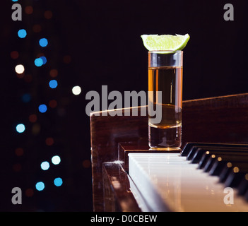 Dankbarkeit für den Maestro, Glas mit Tequila auf einem Klavier. Stockfoto