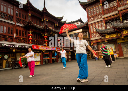 Eine ältere Frau führt die chinesische Fächertanz für Übung in historischen Yu Yuan Garten Shanghai, China Stockfoto