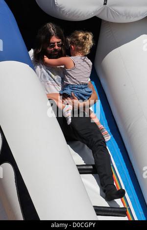 Foo Fighters und Them Crooked Vultures Rocker, Dave Grohl, mit seiner Tochter Violet Maye, spielen auf eine Kinder-Hüpfburg Stockfoto