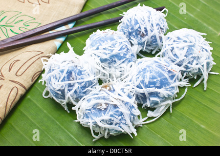 Thai Tradition Dessert mit Bananenscheiben Zeug und Kokos topping auf Bananenblatt. Stockfoto