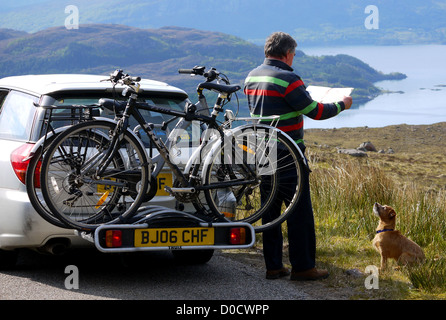 Beratung der Karte während der Fahrt von Applecross, Lochcarron über die Bealach Na Ba pass mit Loch Kishorn im Hintergrund. Stockfoto