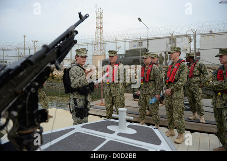 Waffenwart 3. Klasse Andrea Bryant, links, gibt eine Sicherheit kurze, Master Chief Petty Officer der Marine (INTERNIERUNGSLAGER) Mike D. Stevens und Matrosen zugewiesen, die Harbor Patrol Unit des Naval Sicherheitskräfte, Bahrain, bevor man im Gange. Stevens ist visi Stockfoto