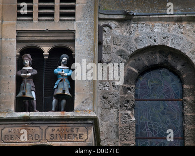 An einer Wand der Stiftskirche Notre-Dame in der Normandie Stadt Auffay sind angehängte zwei hölzerne Glöckner. Stockfoto