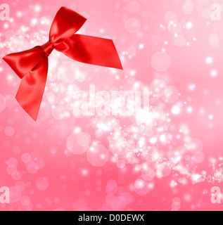 Roter Satin Schleife mit rosa Bokeh leuchtet Hintergrund Stockfoto