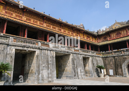 NGO Mon Gate Imperial City Stone Base verzierter hölzerner Pavillon Hue Vietnam / HUE, Vietnam — das NGO Mon Gate dient als Haupteingang der Kaiserlichen Stadt, dessen kunstvoller hölzerner Pavillon – der Lau Ngu Phung oder der Pavillon der fünf Phönixe – auf einer massiven U-förmigen Stein- und Ziegelbasis steht. Das gelb gekachelte Dach des Oberbaus symbolisierte kaiserliche Autorität, und der zentrale Durchgang darunter war ausschließlich den Kaisern von Nguyen vorbehalten. Im August 1945 diente dieser Pavillon als Bühne, auf der der letzte vietnamesische Kaiser Bao Dai formell abdankte, was die 143er Dynastie beendete. Stockfoto