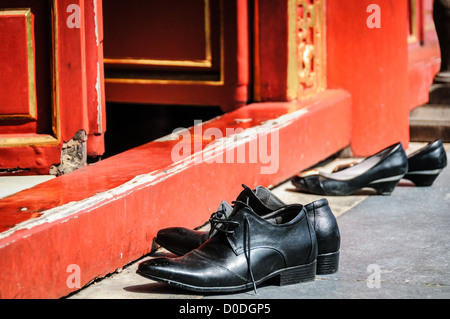 To Mieu Temple Shoes Off Hue Vietnam // HUE, Vietnam – Besucher müssen ihre Schuhe ausziehen, um in den To Mieu Temple in der Kaiserstadt in Hue, Vietnam, zu gehen. Der Komplex ist ein selbstgeschlossener und befestigter Palast und umfasst die lila Verbotene Stadt, die das innere Heiligtum des kaiserlichen Haushalts war, sowie Tempel, Höfe, Gärten und andere Gebäude. Ein großer Teil der Kaiserlichen Stadt wurde während des Vietnamkrieges beschädigt oder zerstört. Sie ist heute zum UNESCO-Weltkulturerbe ernannt. Stockfoto