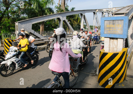 HUE, Vietnam - Morgen Verkehr von Motorrollern, überquert die Cau Phu Xuan Bridge in Hue, Vietnam. Stockfoto