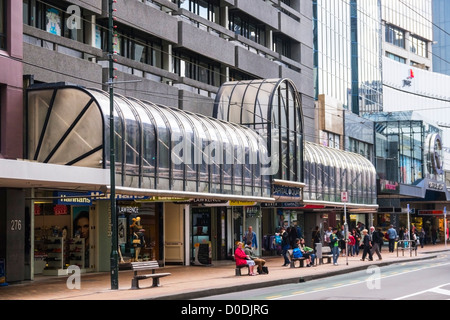 Lambton Quay, der Haupteinkaufsstraße in Wellington, New Zealand, Menschen sitzen auf Bänken, warten an der Bushaltestelle. Stockfoto