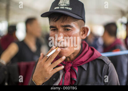 23. November 2012 - Bangkok, Thailand - A Thai Aufruhr Polizist raucht eine Zigarette, während einer Pause vom Dienst Government House in Bangkok vor Anti-Regierungs-Demonstranten zu schützen. Thailändische Behörden haben der Internal Security Act (ISA) verhängt, die ermöglicht die Polizei die Armee bei Bedarf für Ordnung zu sorgen, und Tausende von Bereitschaftspolizei in den Straßen rund um das Regierungsgebäude im Vorgriff auf eine große Anti-Regierungs-Demonstration Samstag gelegt. Die Gruppe sponsoring des Protests, sagte Pitak Siam, bis zu 500.000 Menschen erweisen könnte, um gegen die Regierung zu protestieren. Bildnachweis: ZUMA Press, Inc. / Alamy Live Stockfoto