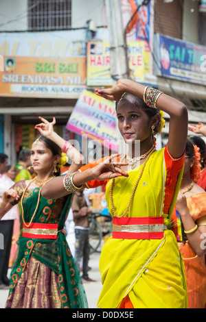 Indische Mädchen in traditioneller Kleidung bei einem Festival in den Straßen von Puttaparthi tanzen. Andhra Pradesh, Indien Stockfoto