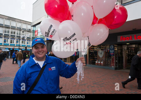 Ein Mitarbeiter verschenkt Ballons bei der Eröffnung der neuen Niederlassung der Metro Bank in Reading, Berkshire am 23. November 2012. Stockfoto