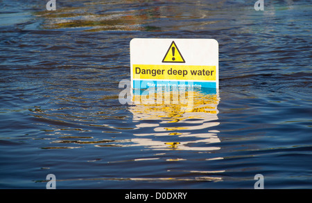 Gefahrenzeichen tiefes Wasser bei Überschwemmungen durch steigende Wasserstände abgedeckt. Stockfoto