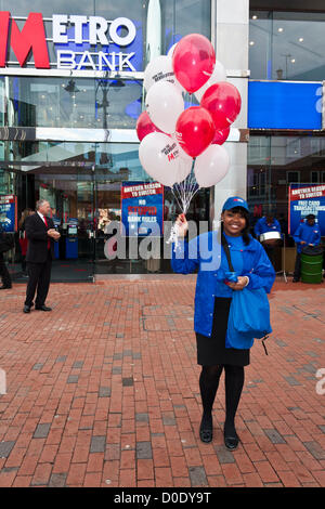 Ein Mitarbeiter verschenkt Ballons bei der Eröffnung der neuen Niederlassung der Metro Bank in Reading, Berkshire am 23. November 2012. Stockfoto