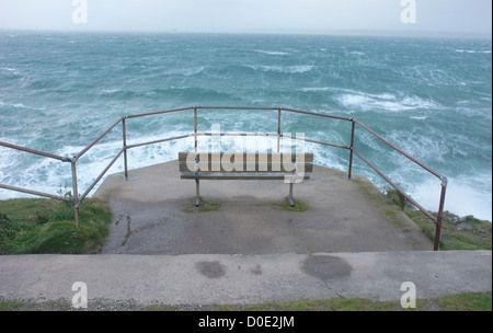 Eine Bank mit Blick auf rauer See in Falmouth, Cornwall, UK. Blick vom Pendennis Point Stockfoto