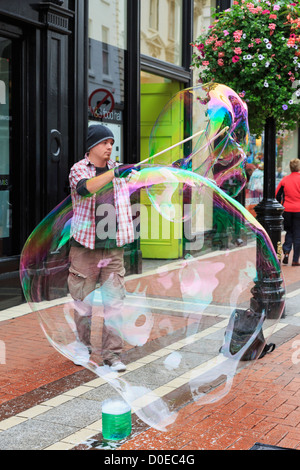 Irische Straße Entertainer machen 2 große Luftblasen mit zwei Stöcken im Stadtzentrum auf der Grafton Street, Dublin, Südirland, Eire Stockfoto