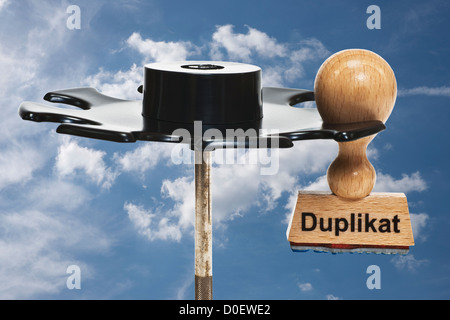 Stempel mit deutscher Inschrift Duplikat (Kopie) hängt in einem Stempel Rack, Hintergrund Himmel Stockfoto