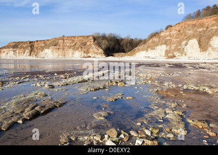 Eine felsige Küste Winter Seenlandschaft mit erodierten Klippen und Strand unter blauem Himmel auf Yorkshires Ostküste Stockfoto