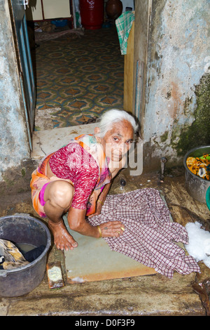 Alte Frau die Wäsche auf der Straße im Dharavi Slum in Mumbai, Indien Stockfoto