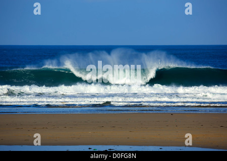 Portreath, Cornwall. Eine Welle bricht am Strand. Stockfoto