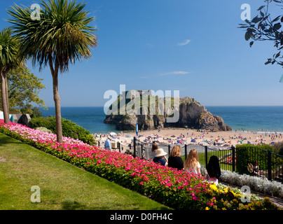 Leute sitzen im Garten mit Blick auf Schloss Beach und St. Catherines Island Tenby Pembrokeshire West Wales UK Stockfoto