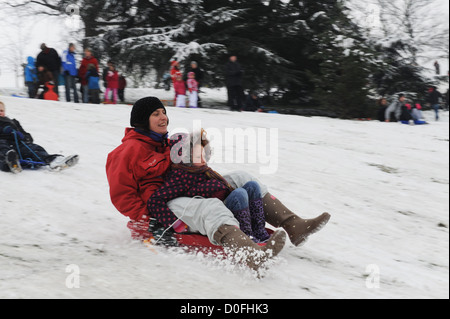 Mutter und Tochter Schlitten die Hänge in Greenwich Park, London, uk Stockfoto