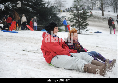 Mutter und Tochter Schlitten die Hänge in Greenwich Park, London, uk Stockfoto