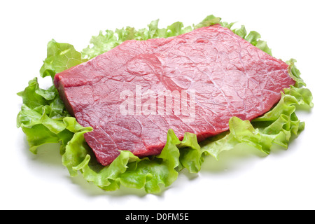 Rohes Fleisch auf Salat verlässt. Isoliert auf weiss. Stockfoto