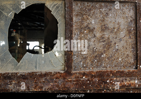 Rostige Fabrik Tür und zerschlagen Glas. Industrielle Grunge Hintergrundtextur. Stockfoto