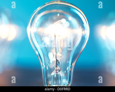 Nahaufnahme der leuchtet Glühbirne auf blauem Hintergrund. Power-Verbrauch-Konzept. Stockfoto
