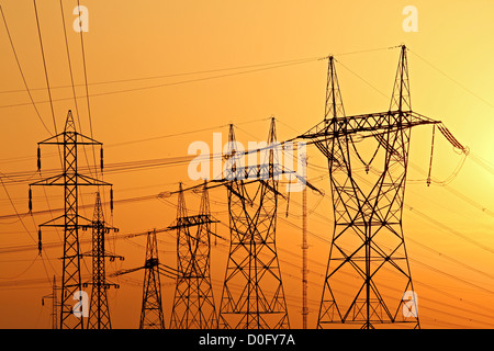 elektrische Hochspannungsmasten während des Sonnenuntergangs Stockfoto