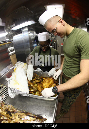 Lance Cpls. LaTrace Thompson, links, ein Food-Service-Spezialist und Ethan Sherer, Funker, beide mit der 24. Marine Expeditionary Unit, bereiten Truthähne am Thanksgiving Day für die Marines und Seeleute an Bord der USS New York, 22. November 2012. Alle th Stockfoto