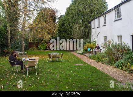 Honiton, Devon, England. 17. Oktober 2012. Zwei Menschen sitzen an separaten Tischen im Garten eines Restaurants. Stockfoto