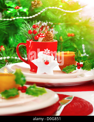 Bild von Weihnachten Tischdekoration mit schönen Weihnachtsschmuck, weiße und rote festliche Utensil, warmes Kerzenlicht Stockfoto