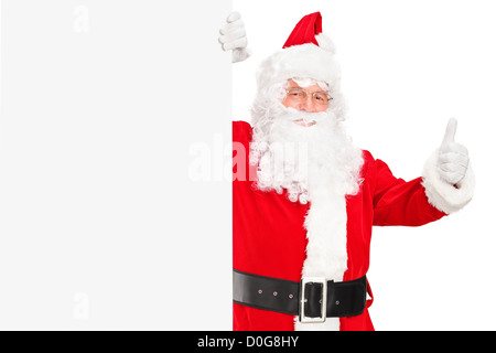 Ein Weihnachtsmann hält ein leeres Plakat und einen Daumen aufgeben Stockfoto