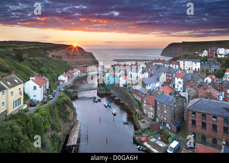 Erhöhten Blick über die Stadt am Meer und den Hafen von Staithes, North Yorkshire bei Sonnenaufgang. Stockfoto