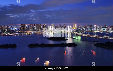 Rainbow Bridge überspannt die Bucht von Tokio mit Tokyo Tower im Hintergrund sichtbar. Stockfoto
