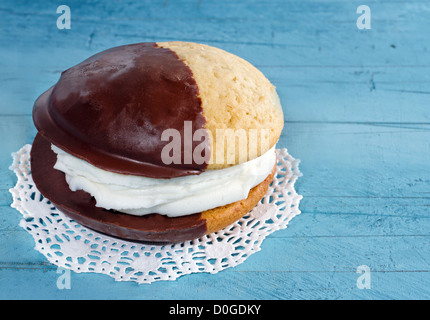 Schokoladen-Whoopie Pie auf blauem rustikalen hölzernen Hintergrund Stockfoto