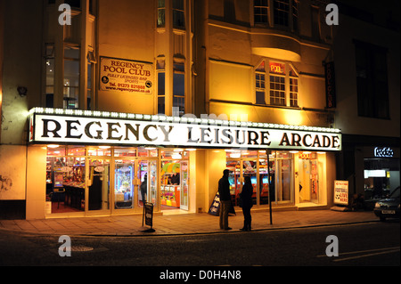 Die Regency-Freizeit mit zwei Personen draußen am Bürgersteig in der Nacht in West Street Brighton UK Stockfoto