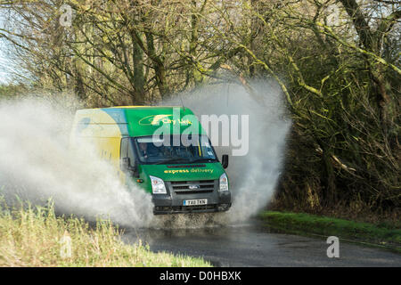 Billericay, Essex, England. Den letzten starken Regen und aufgeweichten Boden führte zu viel Oberflächenwasser in Orten in Essex. Dies hat einige Treiber ertappt, wie sie diese Pfützen mit Geschwindigkeit schlagen die überflutete Motoren und kommen zum Stillstand im Wasser führen kann. Ein City Link van macht Furore durch das Wasser. Stockfoto