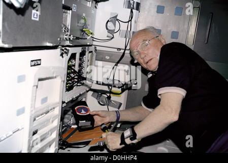 STS-95 Nutzlastspezialisten John Glenn arbeitet mit dem Osteoperose-Experiment im Orbit (OSTEO) Experiment befindet sich in einem Schließfach in th Stockfoto