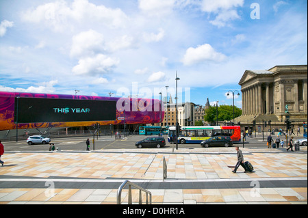 Ein Blick auf der anderen Straßenseite zum Haupteingang des St Georges Hall und einem großen Bildschirm in Liverpool City center außerhalb Lime Street Stockfoto