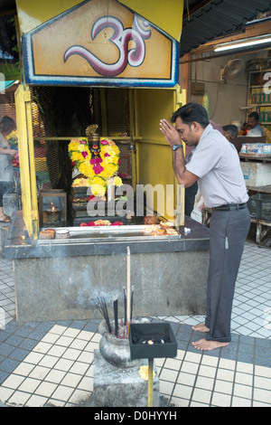 Ein Hindu Anhänger betet in einem Ganesh Schrein in Little India, Penang, Malaysia Stockfoto