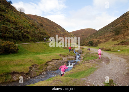 Menschen gehen mit Kindern in Mill Valley, Kardieren Long Mynd, Kirche Stretton, Shropshire Hügel, UK Stockfoto