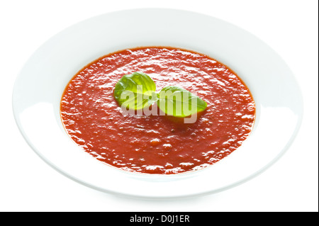 Tomatensuppe mit Basilikum garnieren in einer weißen Schüssel isoliert Stockfoto